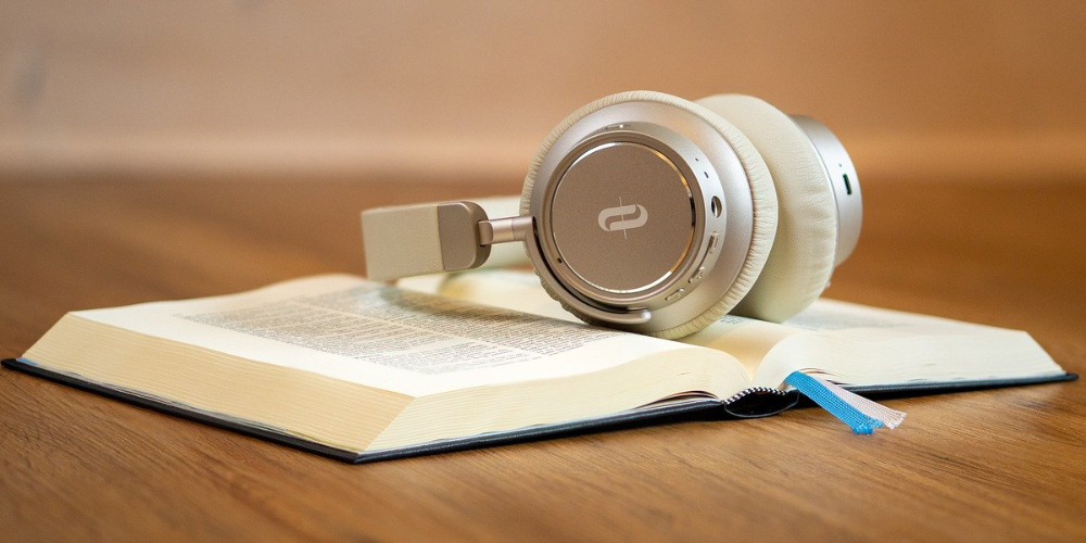 Headphones sitting on a bible on a desk